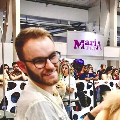 Gustavo na mesa de tosa durante uma competição de grooming, com público ao fundo